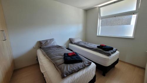 2 camas en una habitación pequeña con ventana en Bright appartment, en Egilsstadir