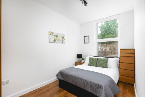 ein weißes Schlafzimmer mit einem Bett und einem Fenster in der Unterkunft Skyvillion - Lovely 2-Bed Central London Apartment in London