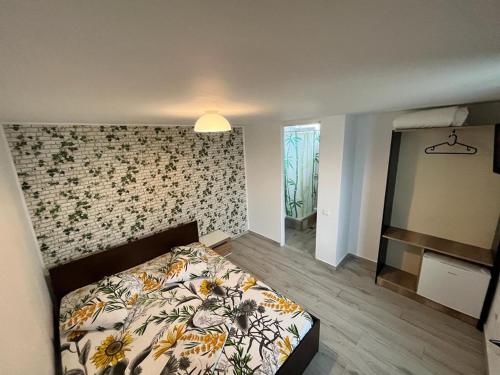 a bedroom with a bed with a flower patterned wall at Estelle in Costinesti