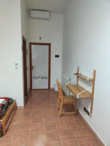 a room with a table and a chair and a door at Beteyà Hostel Don Bosco in Catania