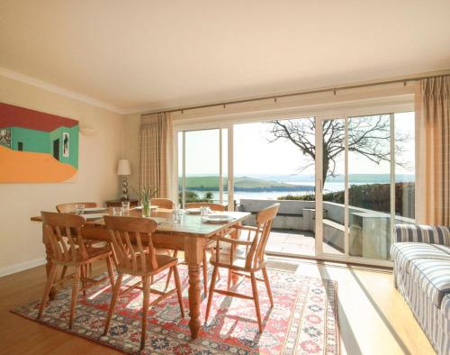 パドストウにあるLittle Strandのテーブルと椅子と大きな窓のあるダイニングルーム