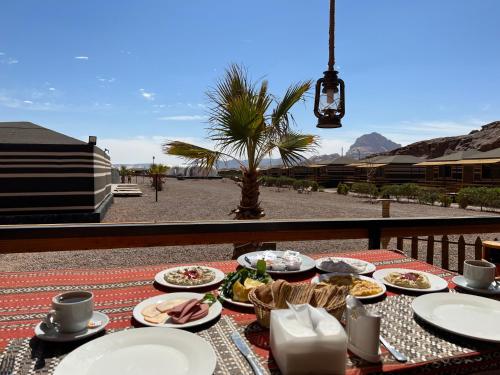 a table with plates of food sitting on a balcony at Rum Oasis Luxury Camp in Wadi Rum