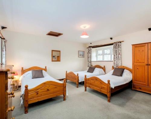 een slaapkamer met 3 bedden in een kamer bij The Granary in Saint Minver