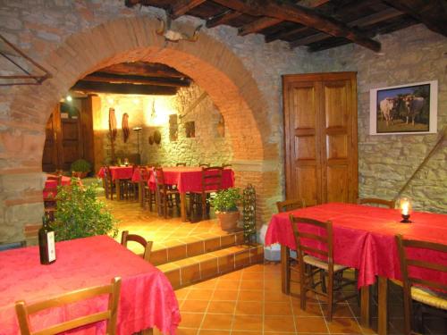 un restaurante con mesas rojas y sillas en una habitación en Agriturismo Botro en Pulicciano