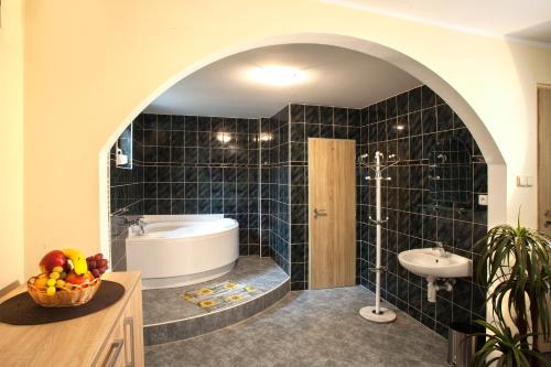 a bathroom with a tub and a sink and a toilet at Pension RELAX U Komína in Františkovy Lázně