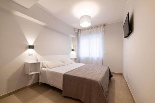 um pequeno quarto com uma cama e uma televisão em Citrarium B&B em Cetraro