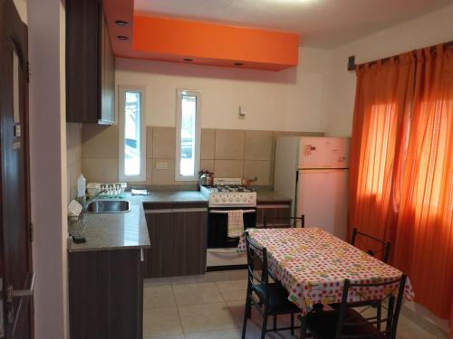 a kitchen with a table and a sink and a refrigerator at Givarolif in Salta