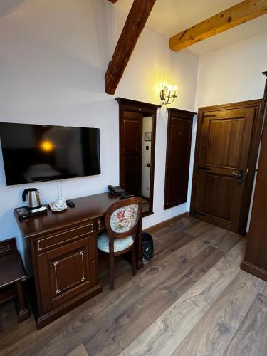 a room with a desk with a flat screen tv at HOTEL BOUTIQUE CASA CHITIC -HOTEL AND RESTAURANT Str Johann Gott nr7 in Braşov