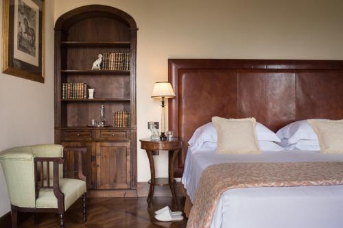 a bedroom with a bed and a table and a chair at Il Borro Relais & Châteaux in San Giustino Valdarno
