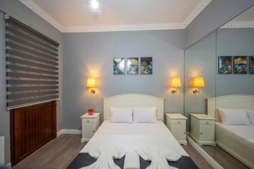 イスタンブールにあるタクシム トレンド レジデンスのベッドルーム1室(白いベッド1台、ナイトスタンド2台付)