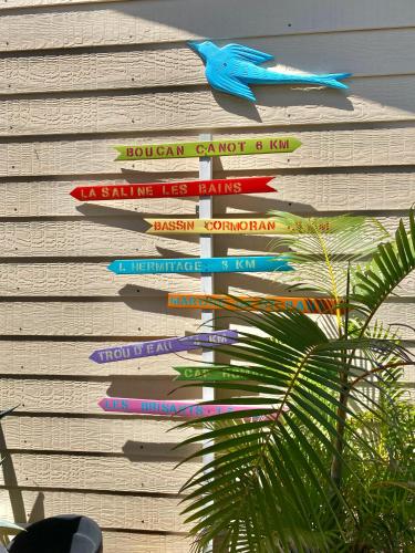 a bunch of signs on the side of a building at Hotel De la Plage in Saint-Gilles les Bains