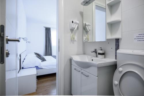 a small bathroom with a sink and a toilet at Stermasi Apartments in Saplunara