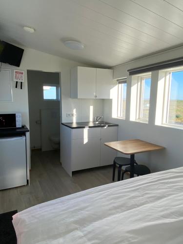 Zimmer mit einem Bett und einer Küche mit einem Tisch in der Unterkunft Uxahryggur in Hvolsvöllur