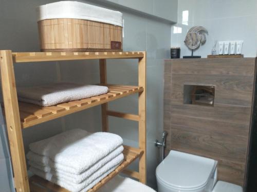 y baño con aseo y una pila de toallas. en Mini Villas Green en Keratokampos