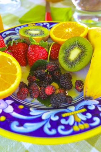 einen Obstteller auf einem Tisch mit Orangen und Erdbeeren in der Unterkunft B&B COLdiFIORE in Penna in Teverina