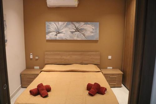 une chambre avec un lit avec deux oreillers rouges dessus dans l'établissement Seaside Accomodation, à Marsaskala