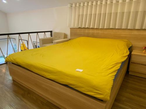 a bed with a yellow blanket on top of it at Gia Hạ House R2.1 View Đồi in Da Lat