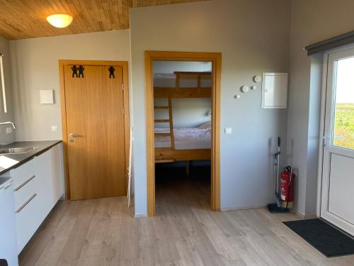 a kitchen with a door leading to a bunk bed at Uxahryggur in Hvolsvöllur