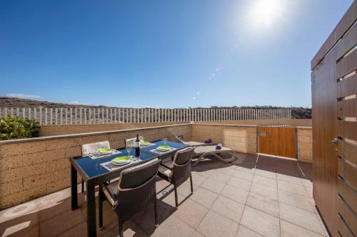 a patio with a table and chairs on a balcony at MEDANO4YOU Scotts Place in El Médano