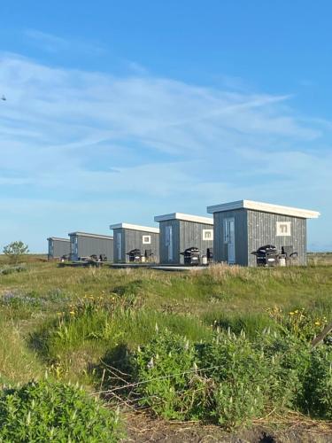 a row of modular buildings in a field at Uxahryggur in Hvolsvöllur