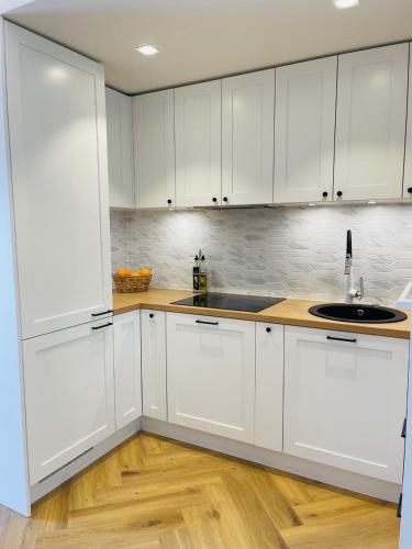a white kitchen with a sink and white cabinets at Villa Alexandra in Otepää