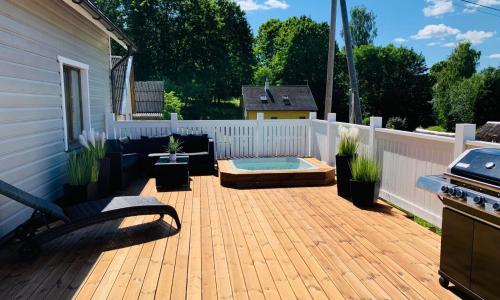 a backyard with a wooden deck with a grill at Villa Alexandra in Otepää