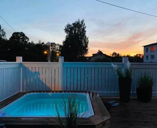 a hot tub in a backyard with a fence at Villa Alexandra in Otepää