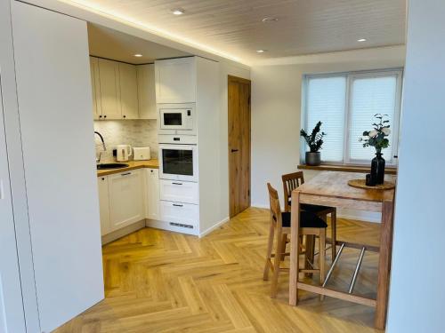 uma cozinha com uma mesa de madeira e uma sala de jantar em Villa Alexandra em Otepää