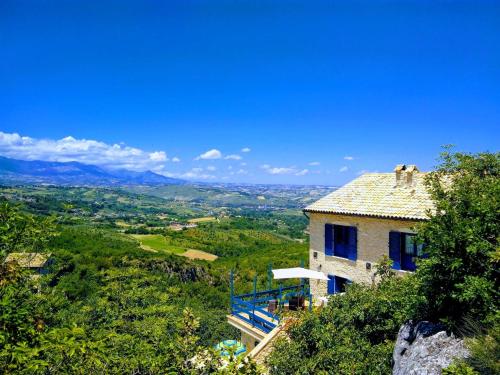 a house on the side of a hill with a view at La casa dalle finestre blu in Abbateggio