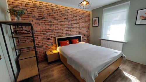 a bedroom with a brick wall and a bed at Apartament Wilczy Potok 400m od wyciągu Beskid Sport Arena - Dream Apart in Szczyrk