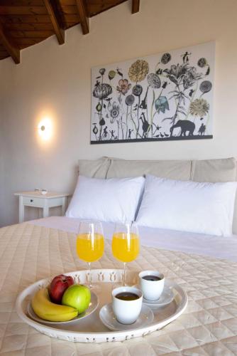 a tray of fruit and glasses of orange juice on a bed at Spacious House with extraordinary view in Corfu in Neochorákion