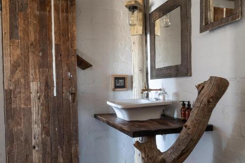 La salle de bains est pourvue d'un lavabo sur un comptoir en bois. dans l'établissement Desert Homestead Lodge, à Sesriem