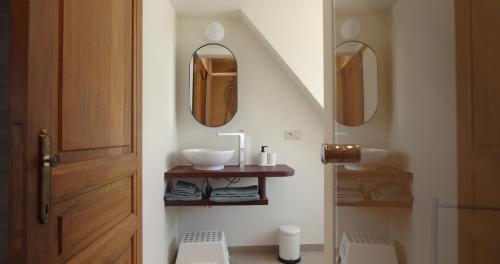 a bathroom with a sink and two mirrors at Berkies - autonome studio in Steenokkerzeel