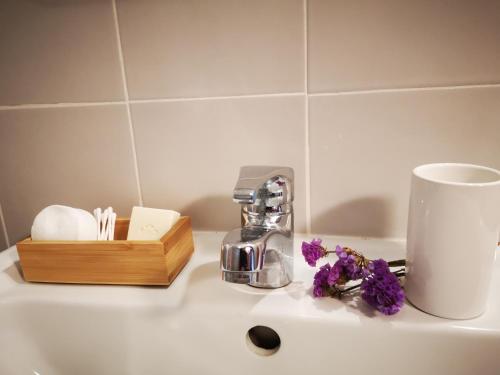 a sink with a coffee maker and flowers on it at Casa do Pontelhão Serra d'Arga in Arga de Cima