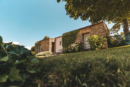 a house on a hill with a green yard at Moinho d'Antoninha in Leomil