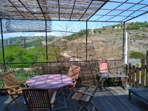 a patio with a table and chairs on a deck at Gîtes de Revirand in Sarras