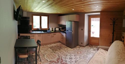 uma cozinha com um sofá, uma mesa e um frigorífico em Chalet Cathy et Michel em Seytroux