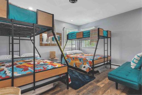 a bedroom with three bunk beds and a couch at Shoreline Splendor Luxury 4 Bedroom Escape in Atlantic City in Atlantic City