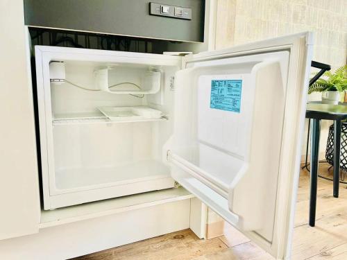 an empty refrigerator with its door open in a kitchen at TIME SHARING STAY Ikebukuro in Tokyo