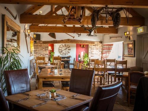 a restaurant with wooden tables and chairs and a clock at The Blackamoor Inn in Ripon