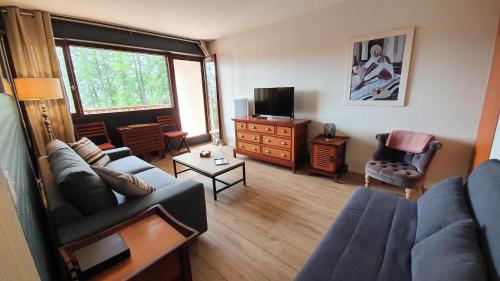 a living room with a couch and a tv at Studio Hyper centre Valberg in Valberg