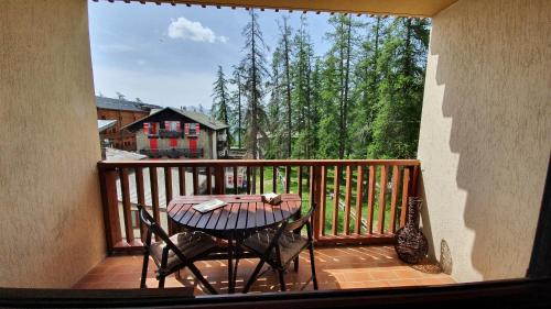 eine Veranda mit einem Tisch und Stühlen auf dem Balkon in der Unterkunft Studio Hyper centre Valberg in Valberg