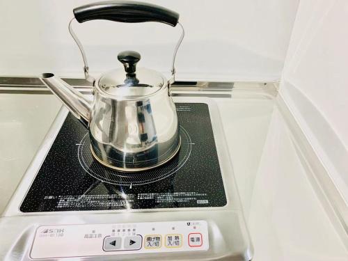 a tea pot sitting on top of a stove at TIME SHARING STAY Ikebukuro in Tokyo
