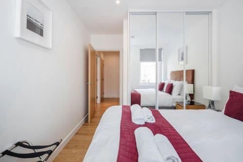 ein Schlafzimmer mit einem großen Bett mit Handtüchern darauf in der Unterkunft Roomspace Serviced Apartments - Swan House in Leatherhead