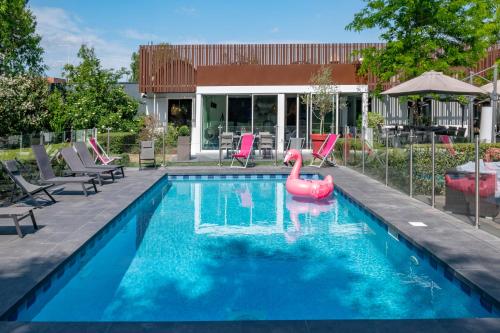 une piscine avec un cygne rose dans l'eau dans l'établissement Novotel Lens Noyelles, à Noyelles-Godault