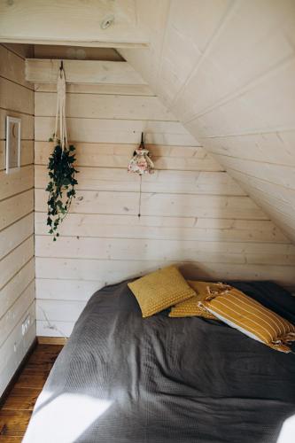 a bed in the corner of a room at "Gaujmale" sauna house in nature in Laukbeitini
