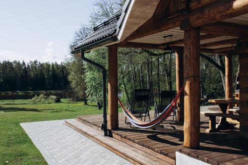 a porch with a hammock in a pavilion at "Gaujmale" sauna house in nature in Laukbeitini