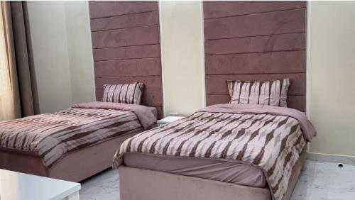 two beds sitting next to each other in a room at Al Jabal Resort villa 1 in Salalah