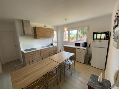 a kitchen with a table and chairs and a refrigerator at Appartement T3 à la Seyne sur mer in La Seyne-sur-Mer