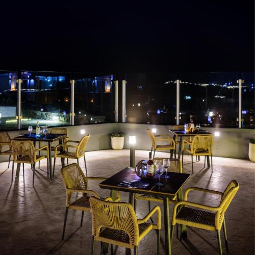 a group of tables and chairs on a patio at night at Kalestesia Suites in Akrotiri